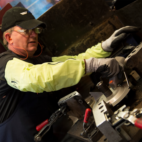 Worker wearing Ansell HyFlex 11-200 sleeve while operating industrial equipment