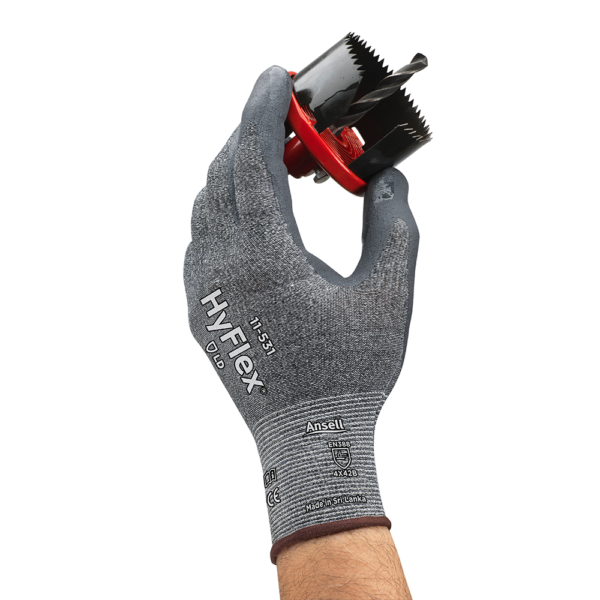 HyFlex 11-531 glove providing cut protection while securely handling a sharp-edged hole saw tool.