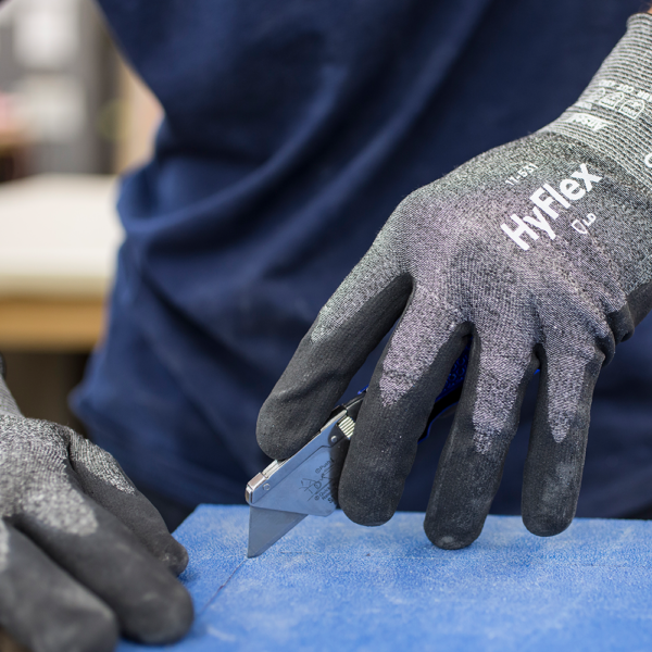 HyFlex 11-531 glove in action, safely gripping a utility knife during precision cutting tasks.