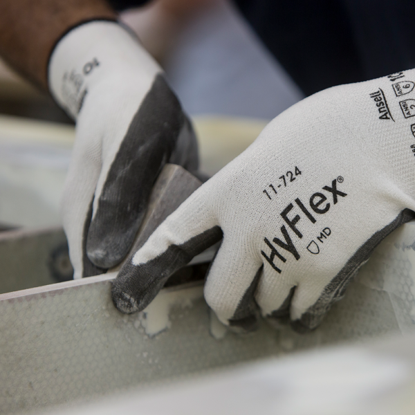 HyFlex 11-724 glove in use for sanding a surface, highlighting grip and abrasion resistance.