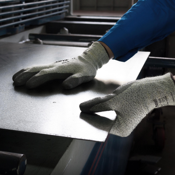 Worker using Ansell HyFlex 11-730 gloves to safely grip and position sheet metal