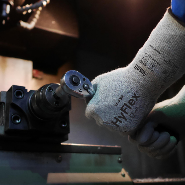 Worker using Ansell HyFlex 11-739 glove to operate machinery in a precision tool setting