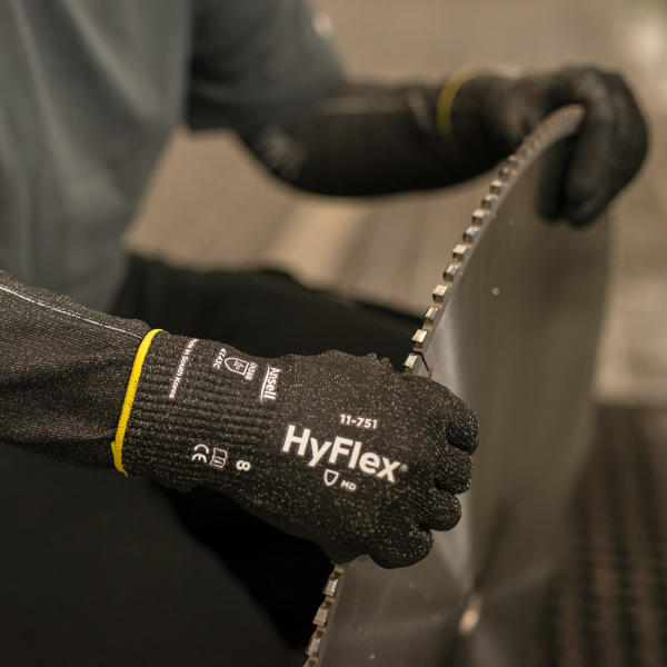 Ansell HyFlex 11-751 gloves in use during industrial blade handling task, showing durability and grip