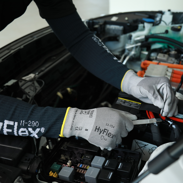 Worker wearing Ansell HyFlex 11-754 gloves while repairing automotive electrical components.