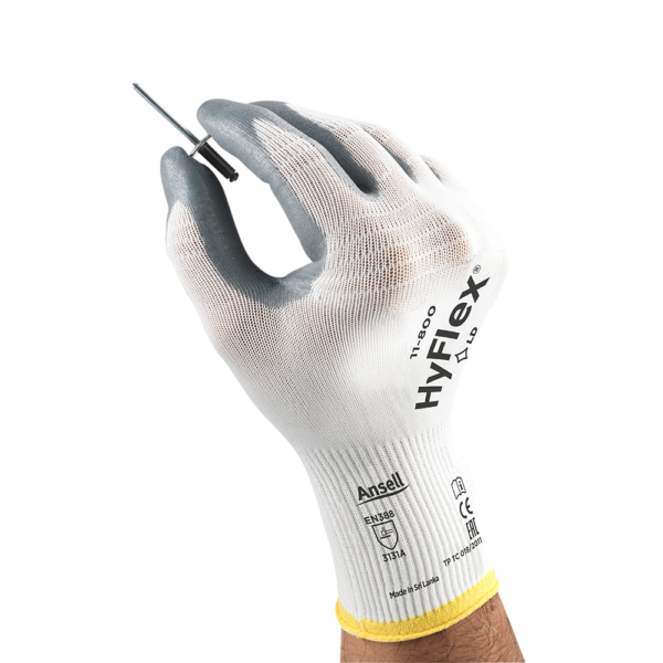 Close-up of HyFlex 11-800 glove holding a small metal tool, demonstrating precision and tactile sensitivity.