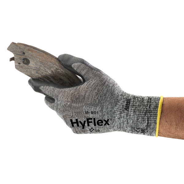 Side profile of Ansell HyFlex 11-801 glove gripping a worn metal brake pad, showcasing tactile control and abrasion resistance.