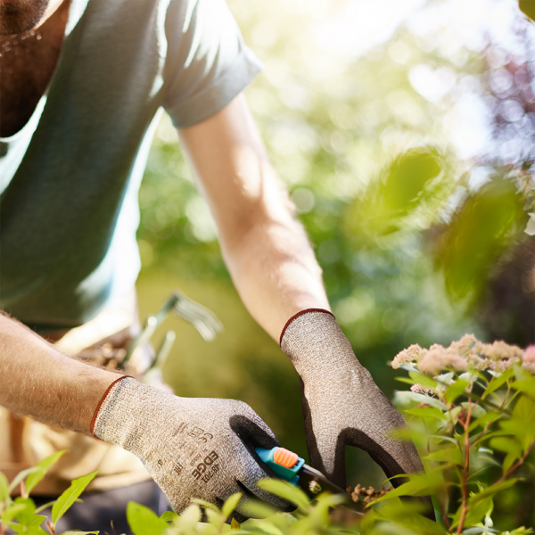 Person gardening outdoors while wearing Ansell EDGE 48-701 gloves for hand protection and dexterity