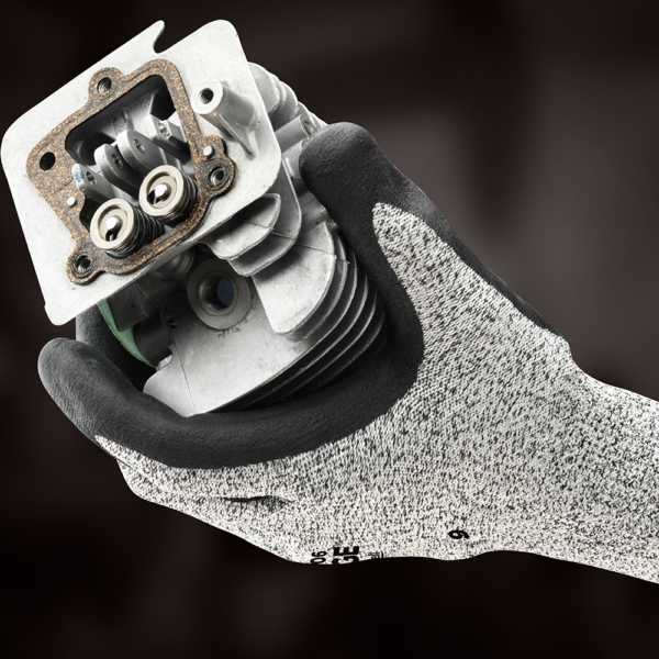 Ansell EDGE 48-706 glove gripping a metal engine part to demonstrate precision handling