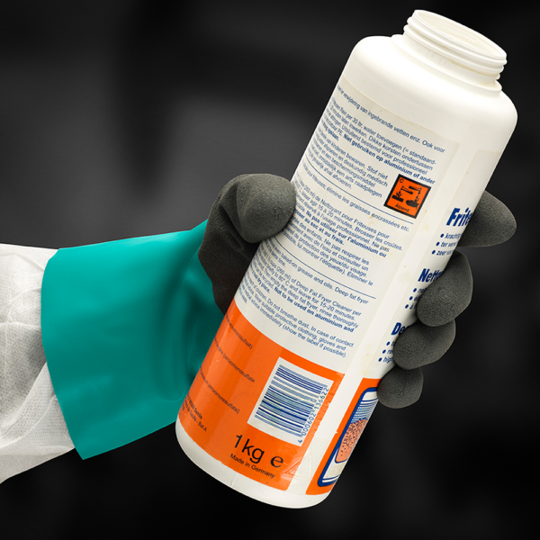 AlphaTec 58-270 glove gripping labelled chemical container in hazardous environment