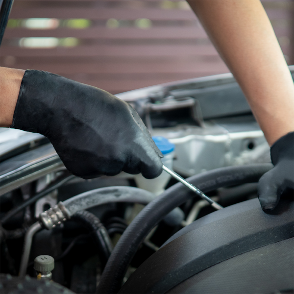 Mechanic wearing Microflex 93-852 gloves while checking car engine oil
