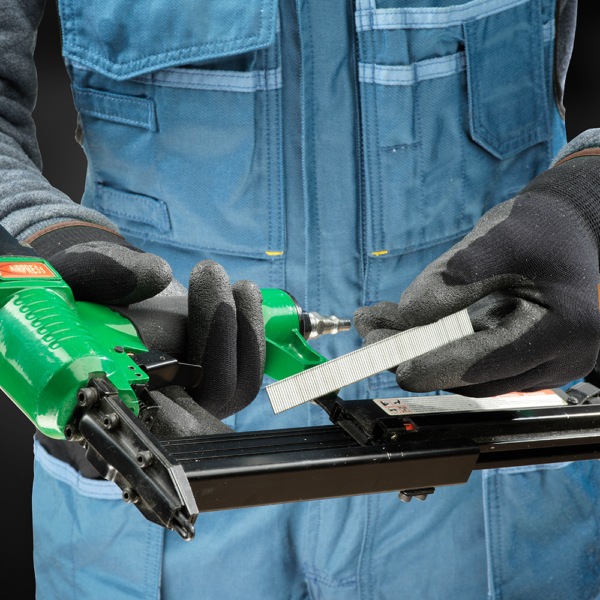 Worker wearing ActivArmr gloves while loading industrial stapler in cold conditions