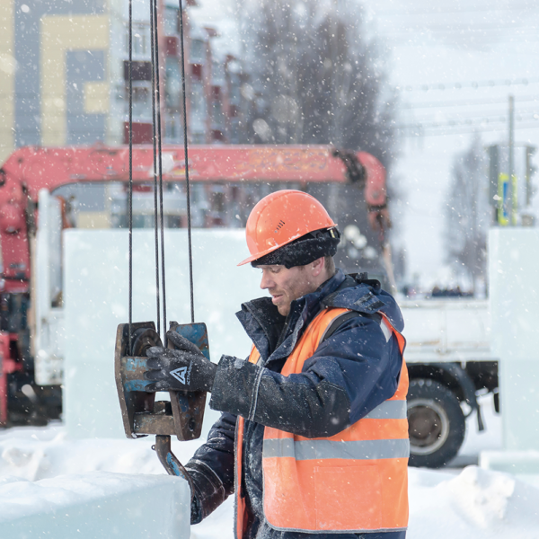 Construction worker operating rigging equipment in snow while wearing ActivArmr insulated gloves