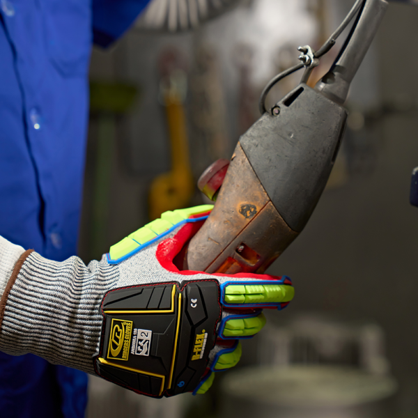 Ringers R065 glove in use while gripping a heavy-duty power tool in an industrial workshop