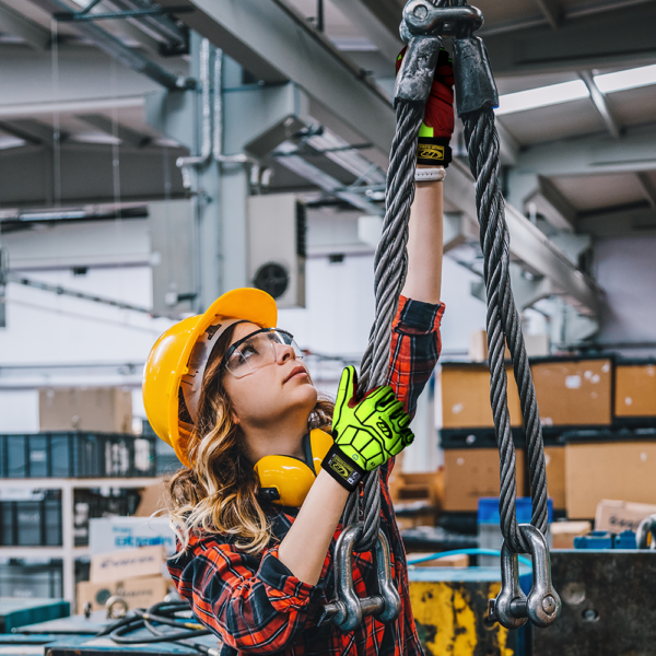Worker wearing Ringers R161 gloves while adjusting steel cables in a warehouse rigging environment