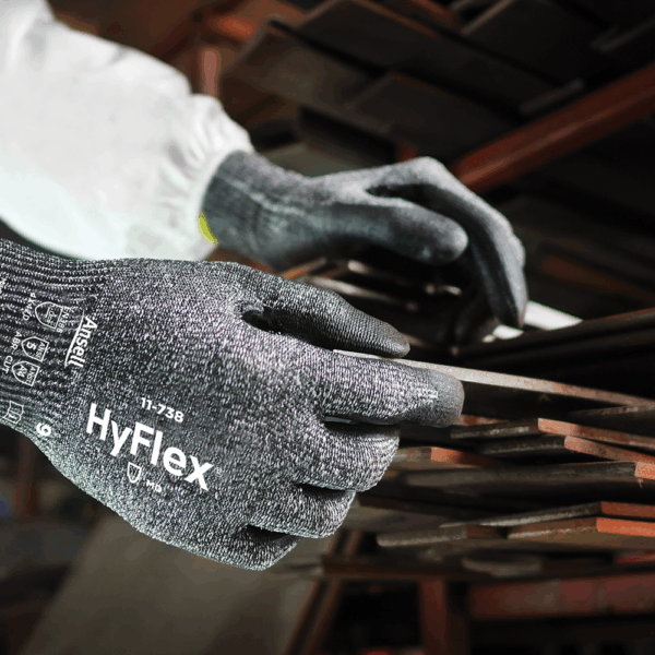 Ansell HyFlex 11-738 gloves used for handling metal rods in a workshop – ideal for precision assembly and sharp edge protection.