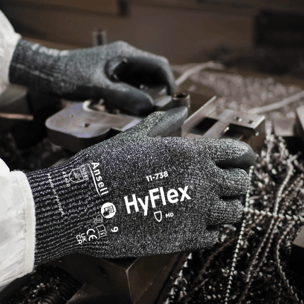 Close-up of Ansell HyFlex 11-738 gloves in use during metal fabrication work – providing grip, comfort and abrasion protection.