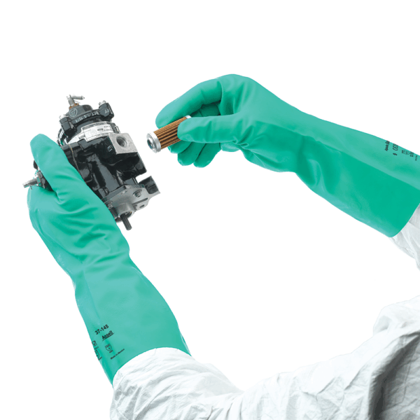 Worker wearing Ansell AlphaTec Solvex 37-145 gloves handling machinery parts – durable chemical protection for maintenance applications.